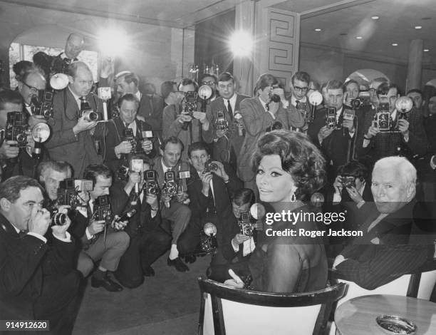English actor Charlie Chaplin with Italian actress Sophia Loren at a press reception at the Savoy Hotel in London, before starting work on the film...
