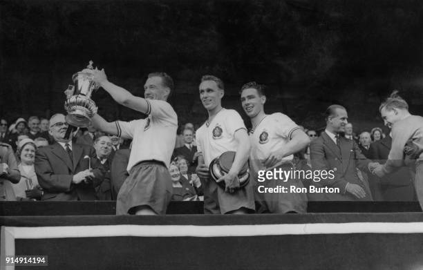 Nat Lofthouse , captain of the Bolton Wanderers, carrying the cup after his team beat Manchester United 2-0 in the FA Cup Final at Wembley, London,...