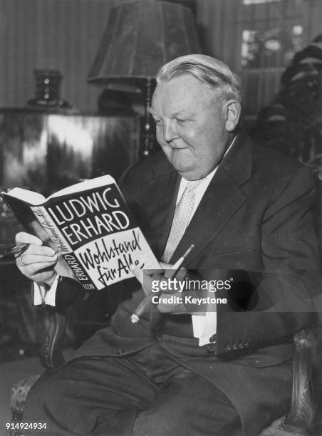 German politician Ludwig Erhard reading a copy of his book 'Wohlstand für Alle', circa 1957.