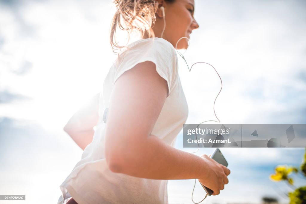 Jeune femme écoutant de la musique et le jogging