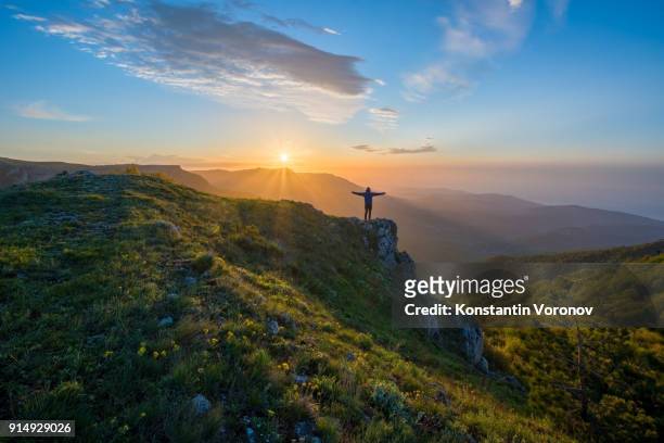 the traveler welcomes the sun at dawn in the highlands. summer landscape with the sun. in the distance you can see the sea. - morning motivation stock pictures, royalty-free photos & images