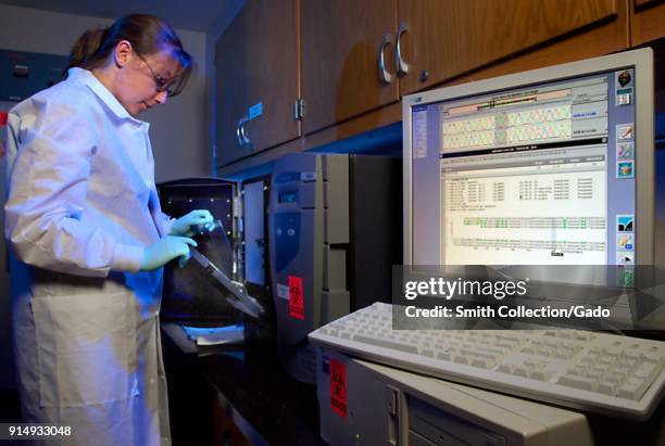 Photograph of Amanda McNulty, a lab researcher at the CDC, working on tests, using the Siemens Trugene System to sequence HIV, HBV and HCV DNA in...