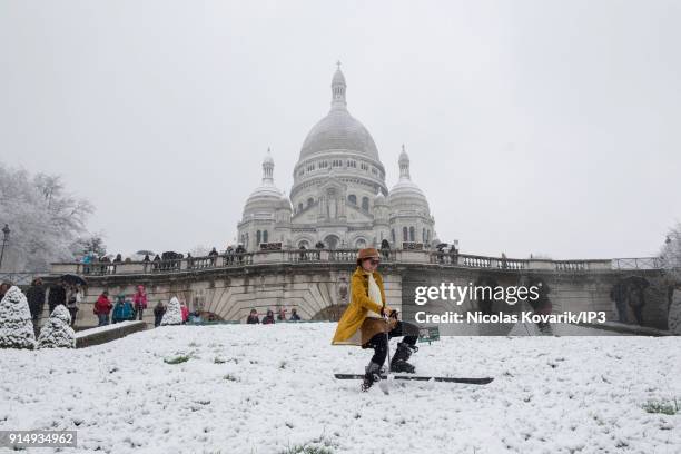 Woman does ski on Montmartre Hill near the Sacre Coeur during a snowfall on February 6, 2018 in Paris, France. Several french departments are...