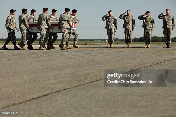 Air Force Colonel Robert Edmondson, U.S. Army Sgt. Maj. Dailey, Maj. Gen. David Perkins and Lt. Gen. David Huntoon salute as soldiers carry the...