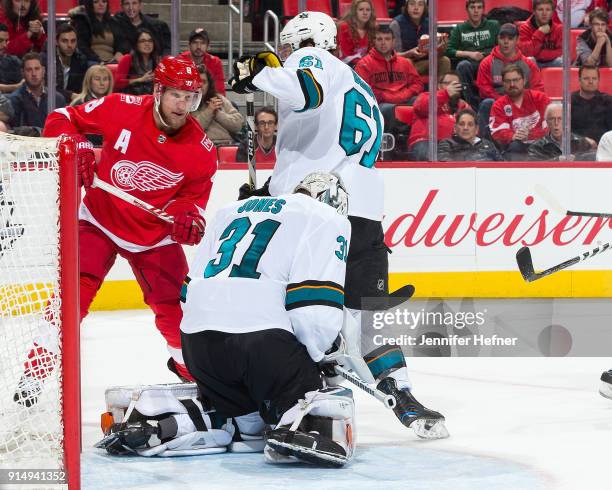 Goaltender Martin Jones of the San Jose Sharks makes a save as teammate Justin Braun defends against Justin Abdelkader of the Detroit Red Wings...