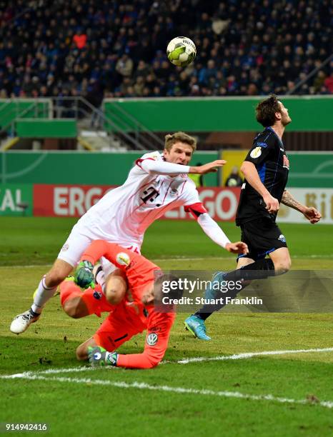 Michael Ratajczak , goalkeeper of Paderborn tackles Thomas Mueller of Muenchen during the DFB Cup quarter final match between SC Paderborn and Bayern...