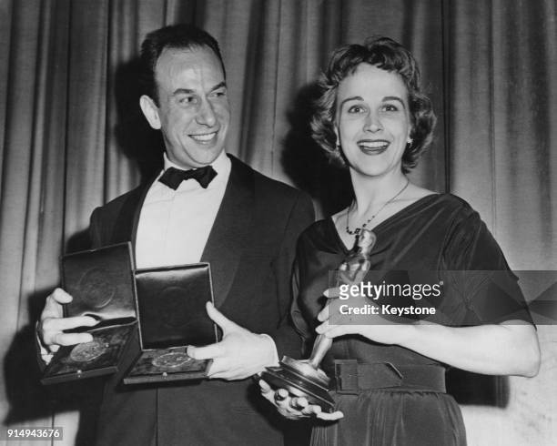 Actors José Ferrer and Kim Hunter present each other with recently-won awards before the world premiere of their latest film 'Anything Can Happen' at...