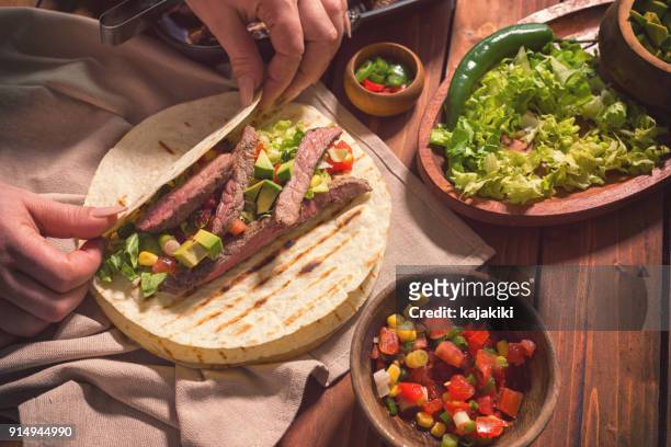 förbereder nötkött kött tacos - female eating chili bildbanksfoton och bilder