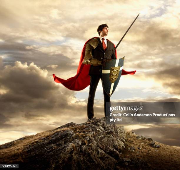businessman in cape holding shield and sword - action hero ストックフォトと画像