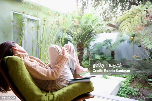 hispanic woman relaxing in chair - patio furniture stock pictures, royalty-free photos & images