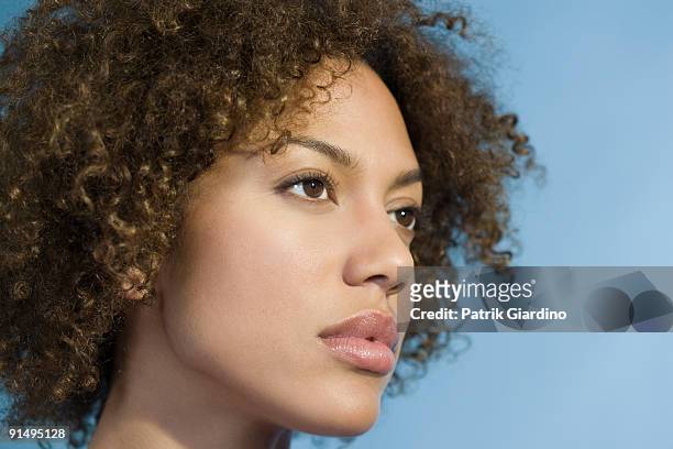 mixed race woman with curly hair - isolated women serieus sad stockfoto's en -beelden