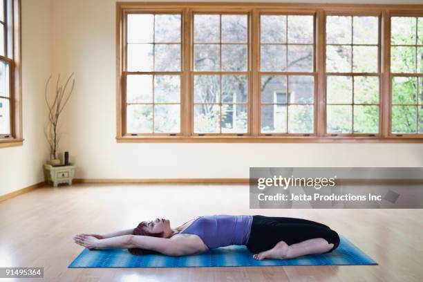 asian woman practicing yoga - auf dem rücken liegen stock-fotos und bilder