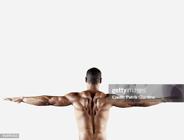 bare chested mixed race man with arms outstretched - mixed race man standing studio stockfoto's en -beelden