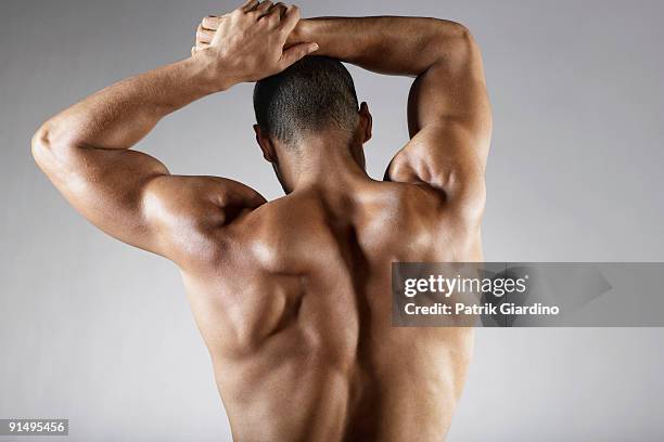 bare chested mixed race man with arms raised - mixed race man standing studio stockfoto's en -beelden
