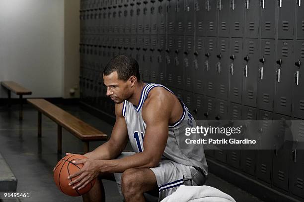 mixed race basketball player sitting in locker room - basketball bench stock pictures, royalty-free photos & images