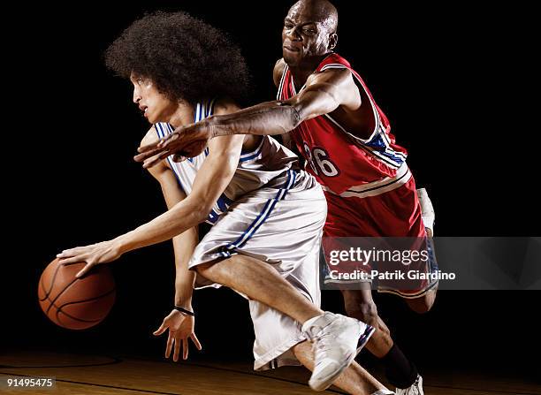 basketball player trying to take basketball from opponent - uniforme de basquete - fotografias e filmes do acervo