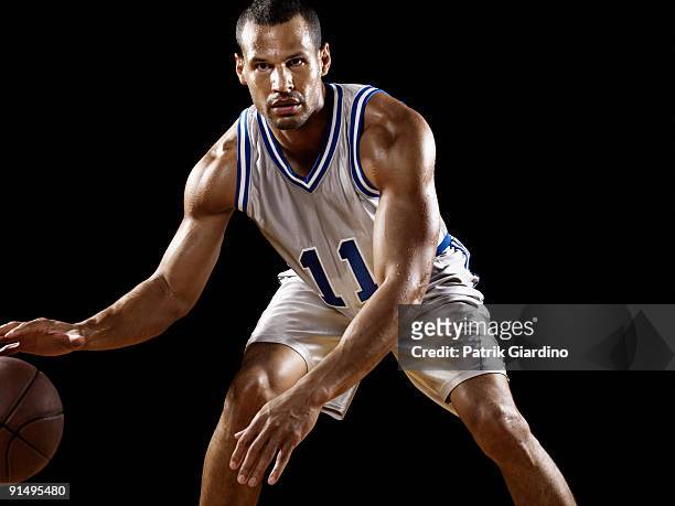 mixed race basketball player bouncing basketball - mixed race man standing studio stockfoto's en -beelden