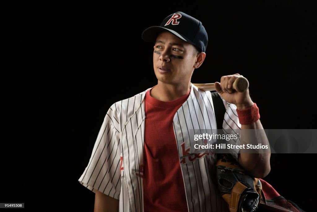 Mixed race baseball player holding bat