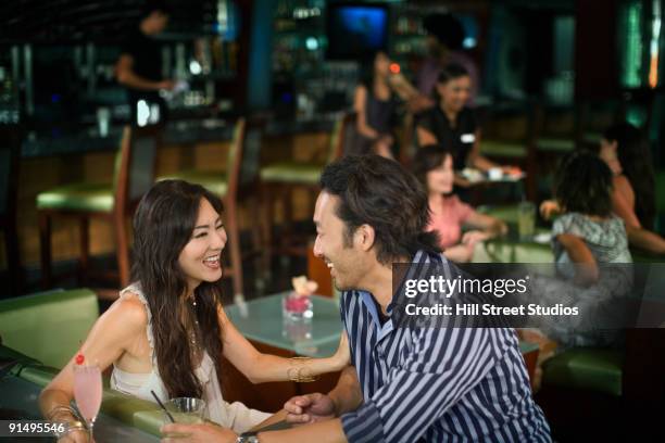 multi-ethnic couple drinking cocktails in nightclub - couple bar stock pictures, royalty-free photos & images