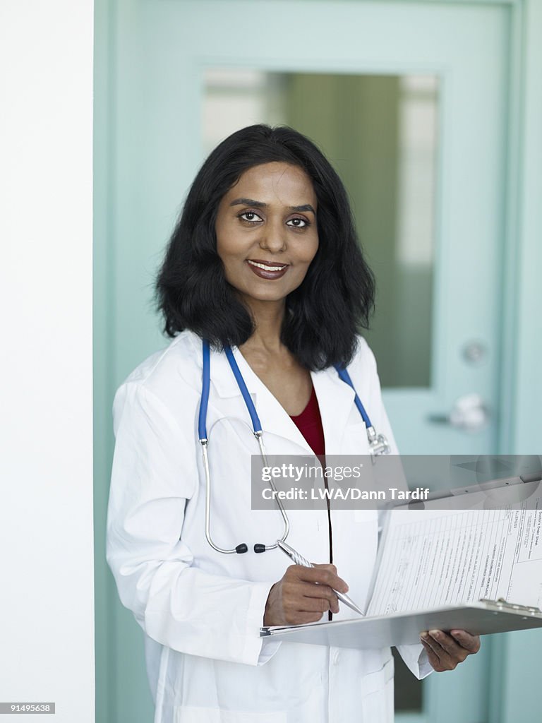 Indian doctor writing in medical chart