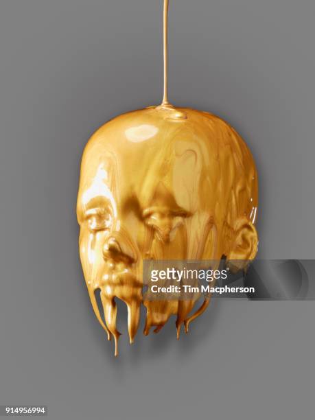 a human mask of poured gold paint - bling bling fotografías e imágenes de stock