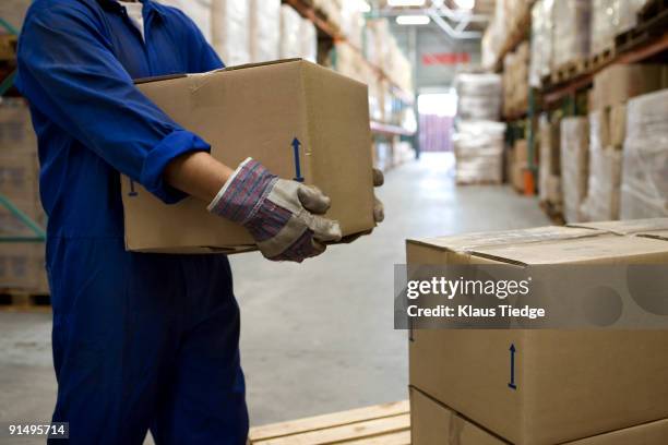 worker carrying boxes in warehouse - middle age imagens e fotografias de stock