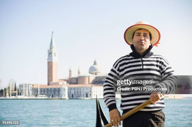 italian gondolier with church in background - venedig gondel stock-fotos und bilder