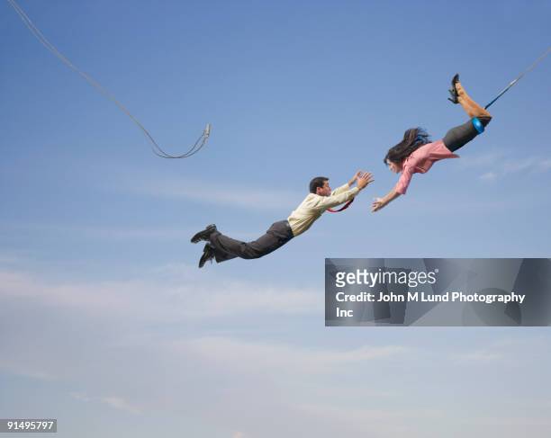 business people on flying trapeze - schommelen bungelen stockfoto's en -beelden