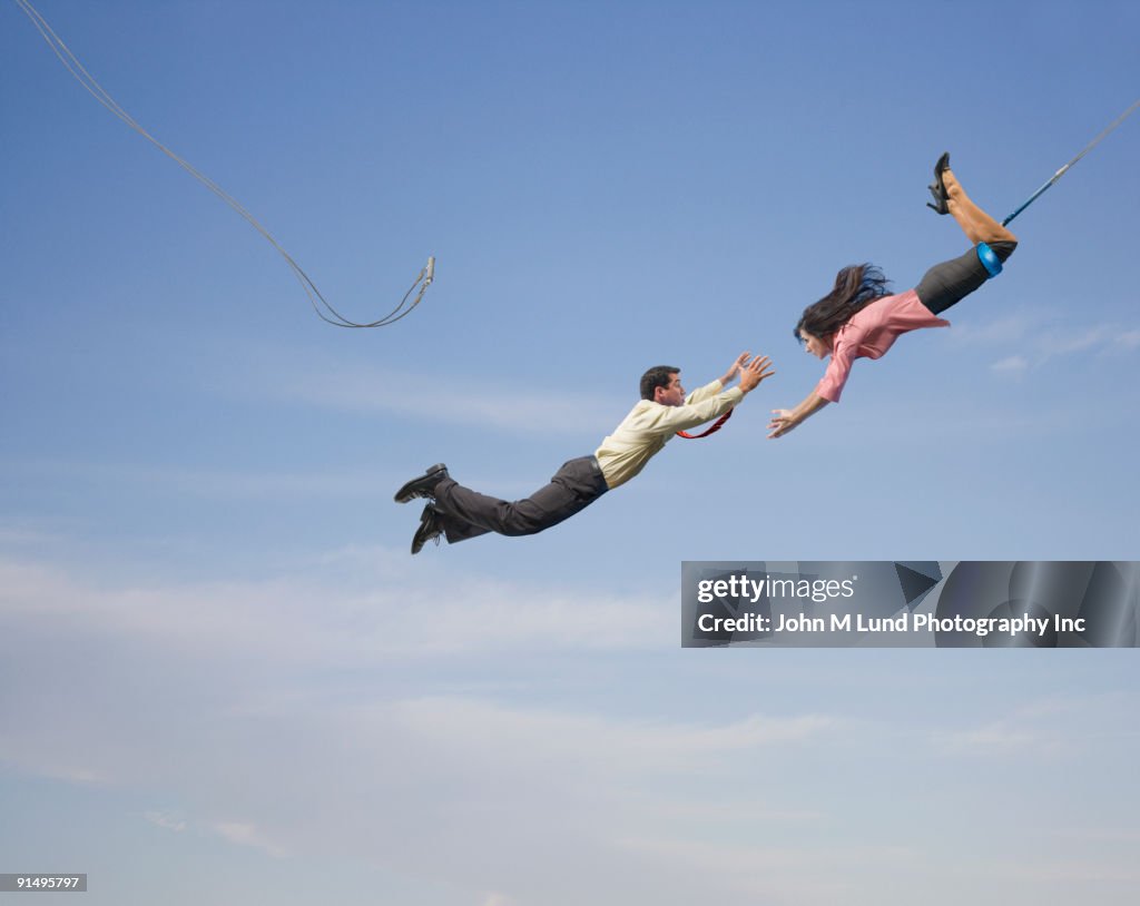 Business people on flying trapeze