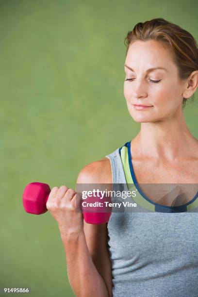 mixed race woman lifting hand weight - womens hand weights stock pictures, royalty-free photos & images