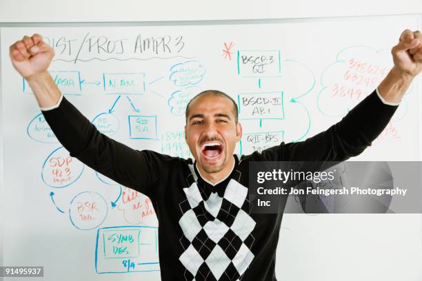 middle eastern businessman cheering in front of whiteboard - teacher in front of whiteboard stock pictures, royalty-free photos & images