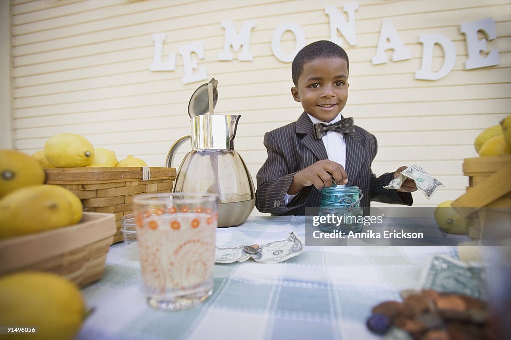 Mixed race boy in suit selling lemonade