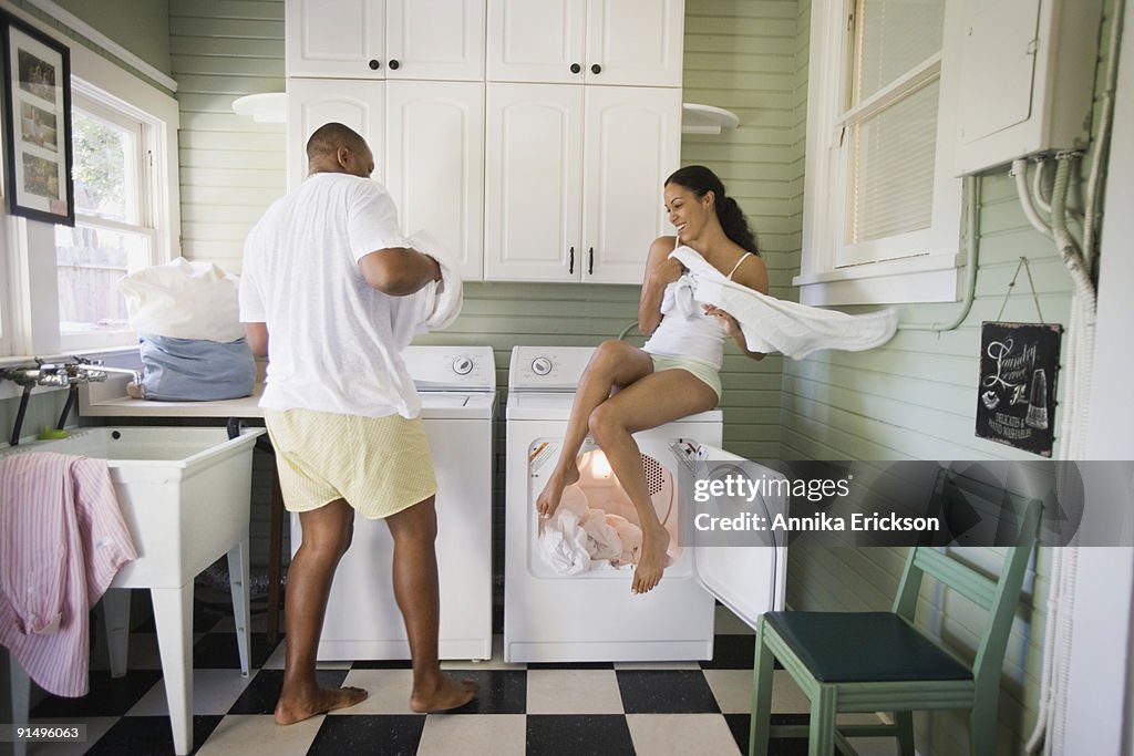 Playful couple folding laundry