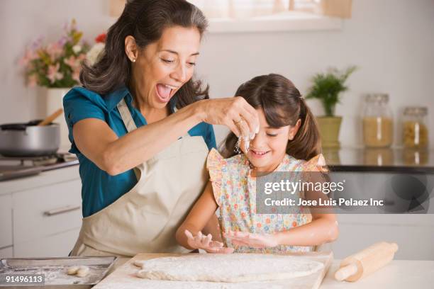 hispanic grandmother and granddaughter preparing dough - baking stock pictures, royalty-free photos & images