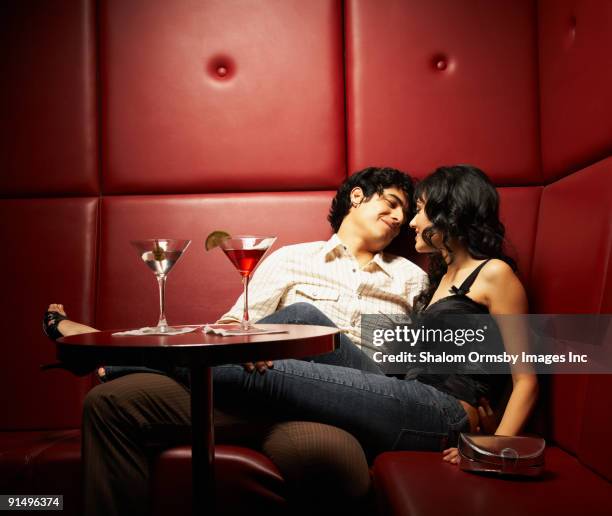 hispanic couple cuddling in nightclub - seduzione foto e immagini stock