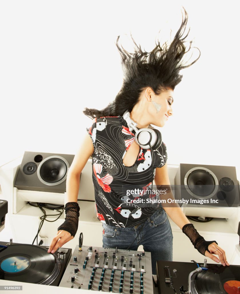 Hispanic dj with turntable and sound mixer