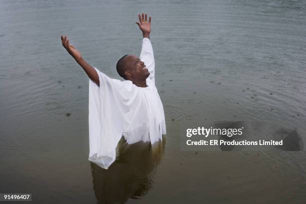 african man getting baptized in lake - black baptism stock pictures, royalty-free photos & images