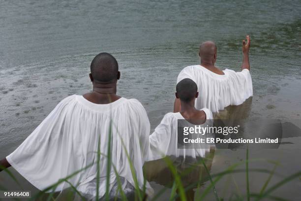 african men and boy getting baptized in lake - black baptism stock pictures, royalty-free photos & images
