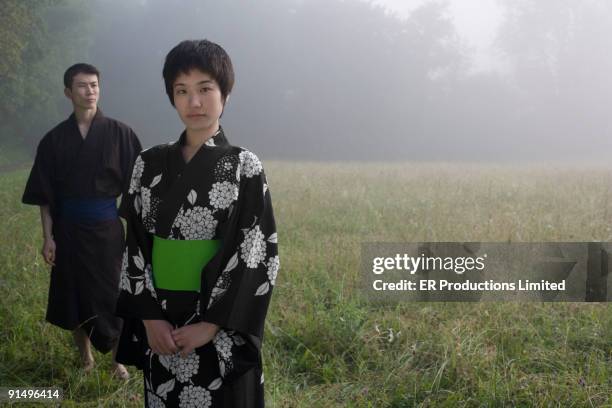 asian couple wearing traditional robes standing in field - obi sash fotografías e imágenes de stock