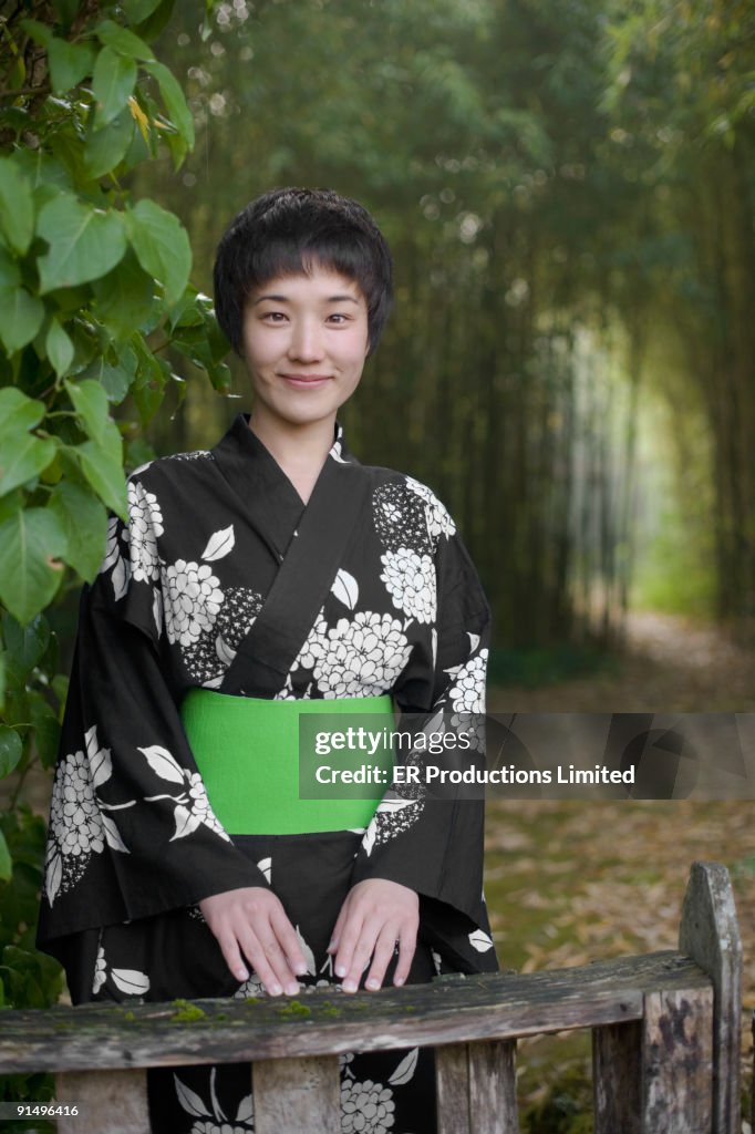 Asian woman wearing traditional robe in forest