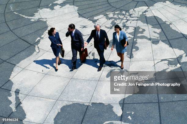 businesspeople walking on map of globe - worldwide businessman stockfoto's en -beelden