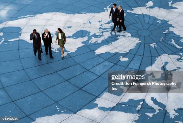 businesspeople walking on map of globe - global stock-fotos und bilder