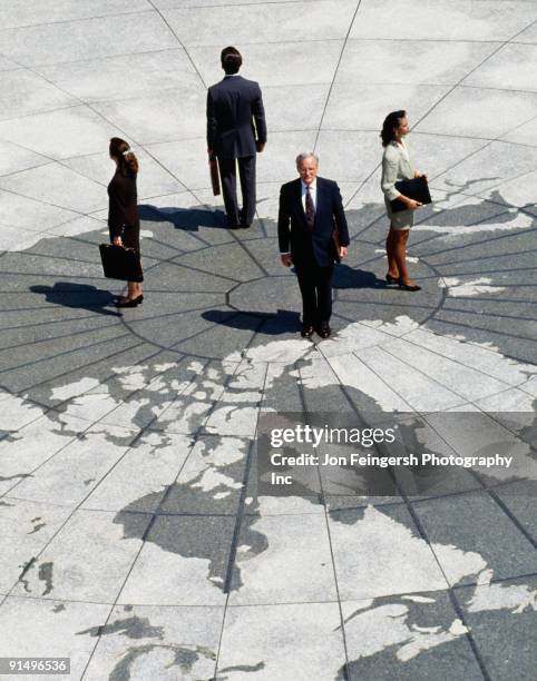 businesspeople standing on map of globe - businessman looking at map stock pictures, royalty-free photos & images