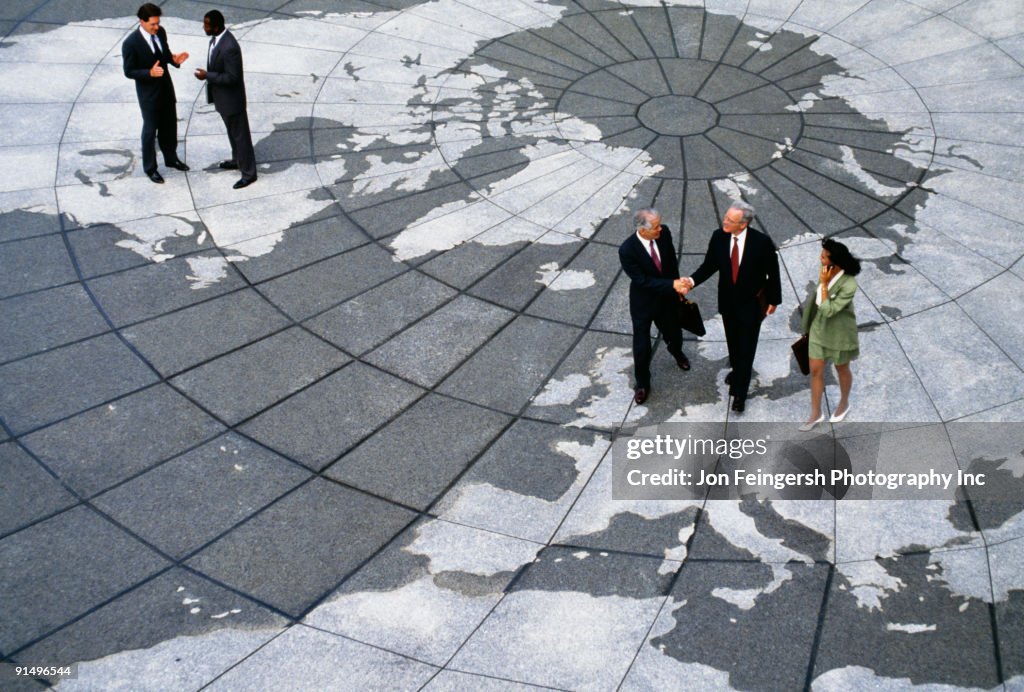 Businesspeople walking on map of globe