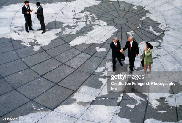 businesspeople walking on map of globe - global partnership stock pictures, royalty-free photos & images