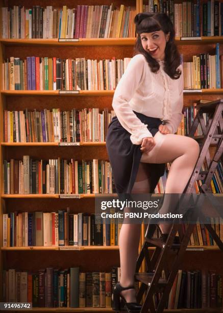 woman in retro clothing on library ladder - latina glamour models stock pictures, royalty-free photos & images