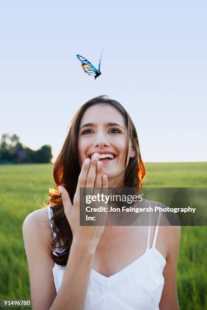 woman watching butterfly in meadow - insect photos free stock pictures, royalty-free photos & images