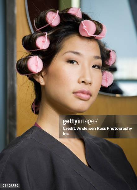 asian woman with curlers in hair - hair curlers stockfoto's en -beelden