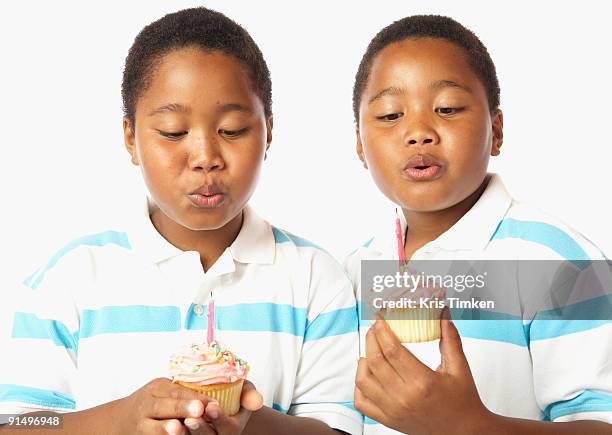 young african twin brothers holding cupcakes with candles - somente crianças - fotografias e filmes do acervo