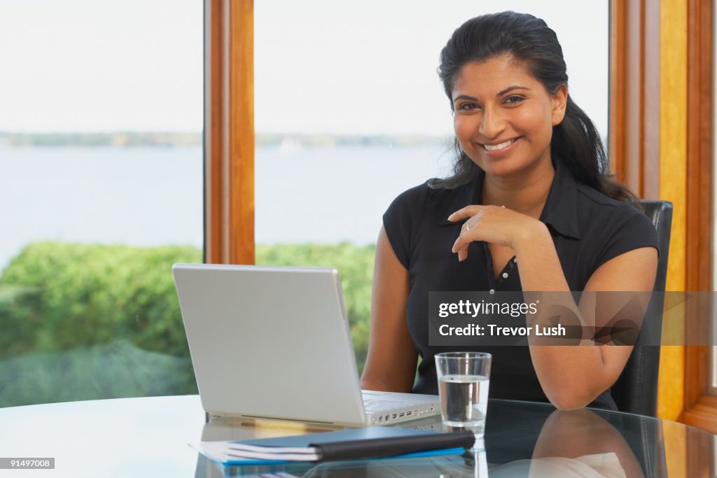 Indian woman at table with laptop